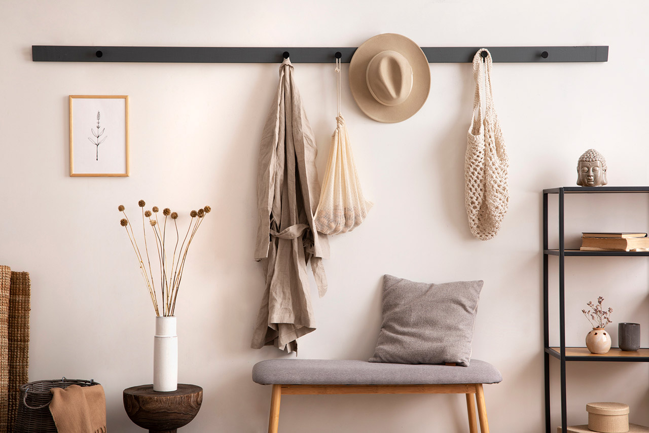 Cosy entryway with grey bench, coffee table, hanger and personal accessories stock photo